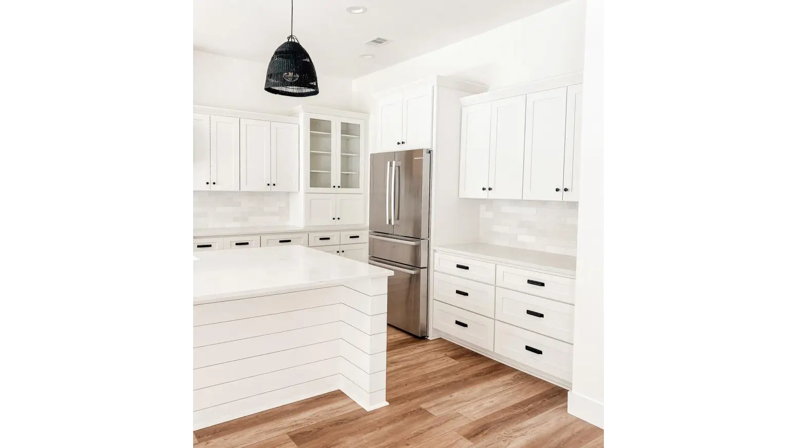 Contemporary white kitchen featuring elegant wood floors and Weston White Shaker Kitchen Cabinets